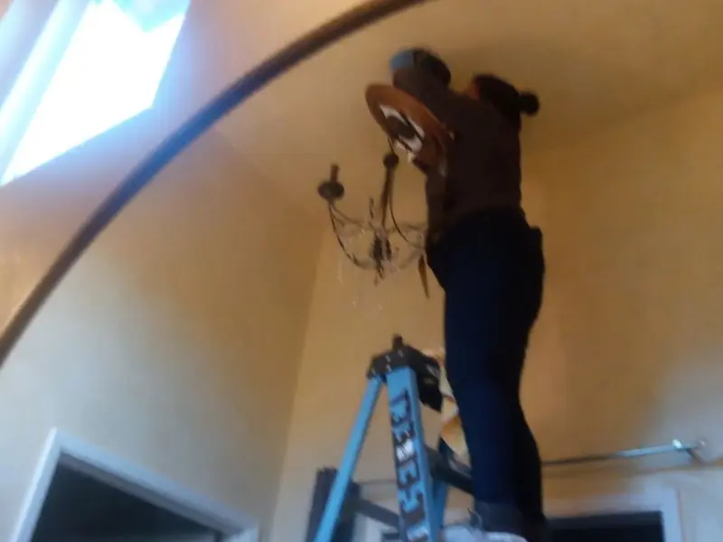 Electrician installing a chandelier in a Guadalupe residence